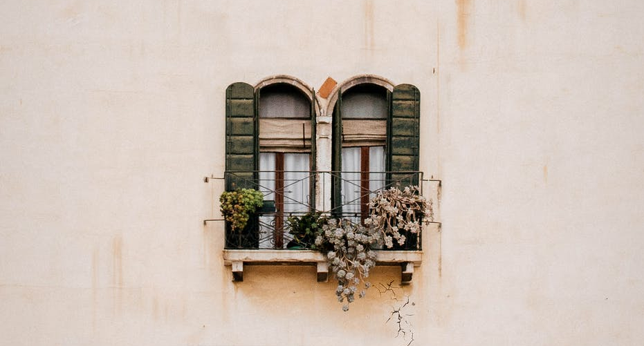 green wooden window on white concrete wall
