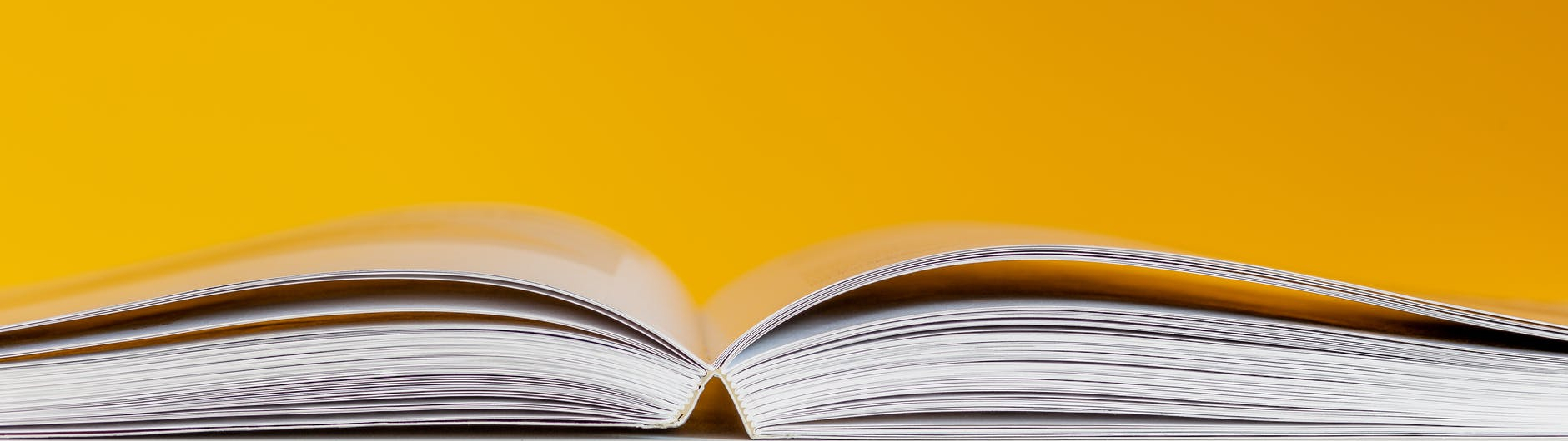 white book in white table near yellow wall