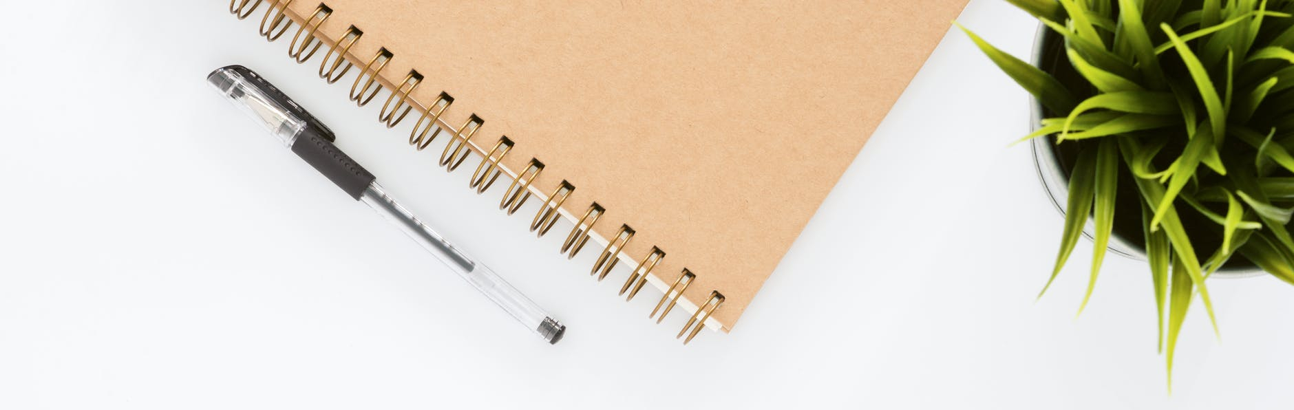 black ball point pen with brown spiral notebook